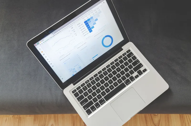Overhead view of a laptop displaying a website analytics dashboard with a traffic trend chart and channel breakdown