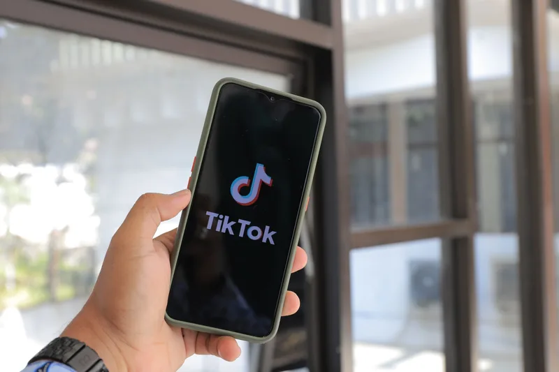 Close-up of a hand holding a smartphone displaying the TikTok app