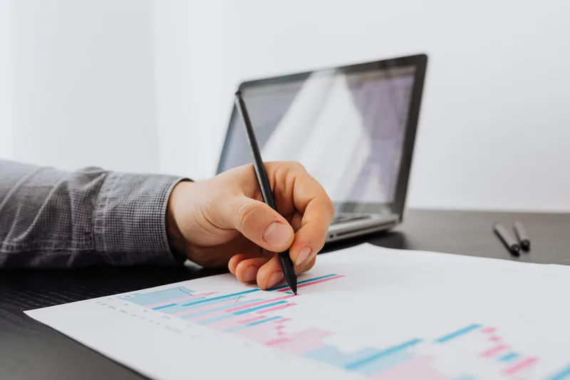 Person reviewing engagement data and taking notes on a laptop at a desk