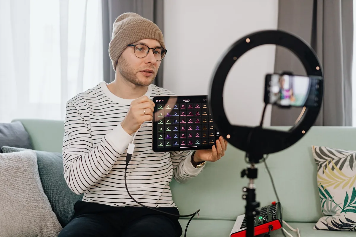 Content creator filming a product review video with a smartphone and ring light for a social media post