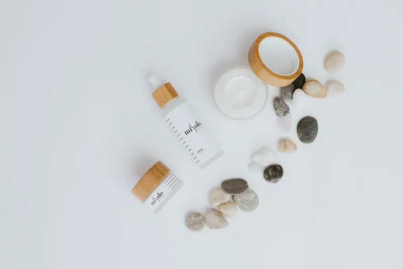 Flat lay product photo of skincare bottles and jars styled on a white background
