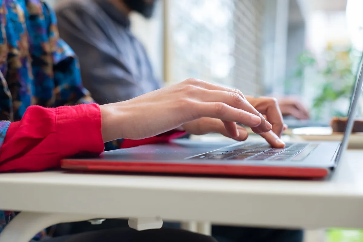 Person typing on a laptop, setting up email marketing for an online store